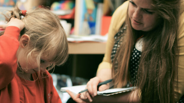 Female teacher helping pupil with school work