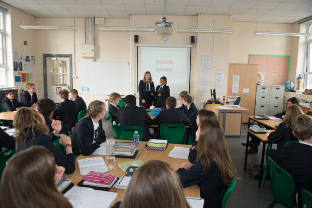 Two secondary pupils presenting at the front of a classroom