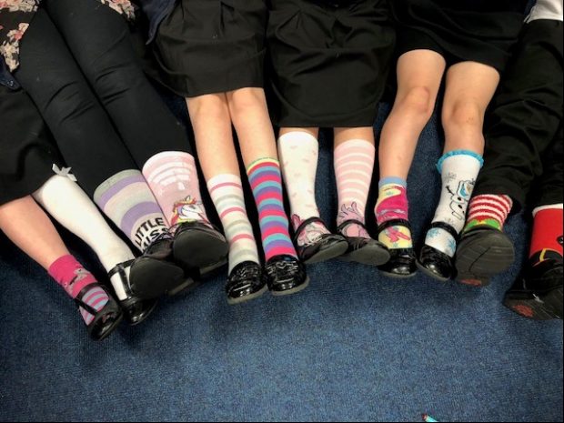 Several sets of children's legs, each with odd socks.