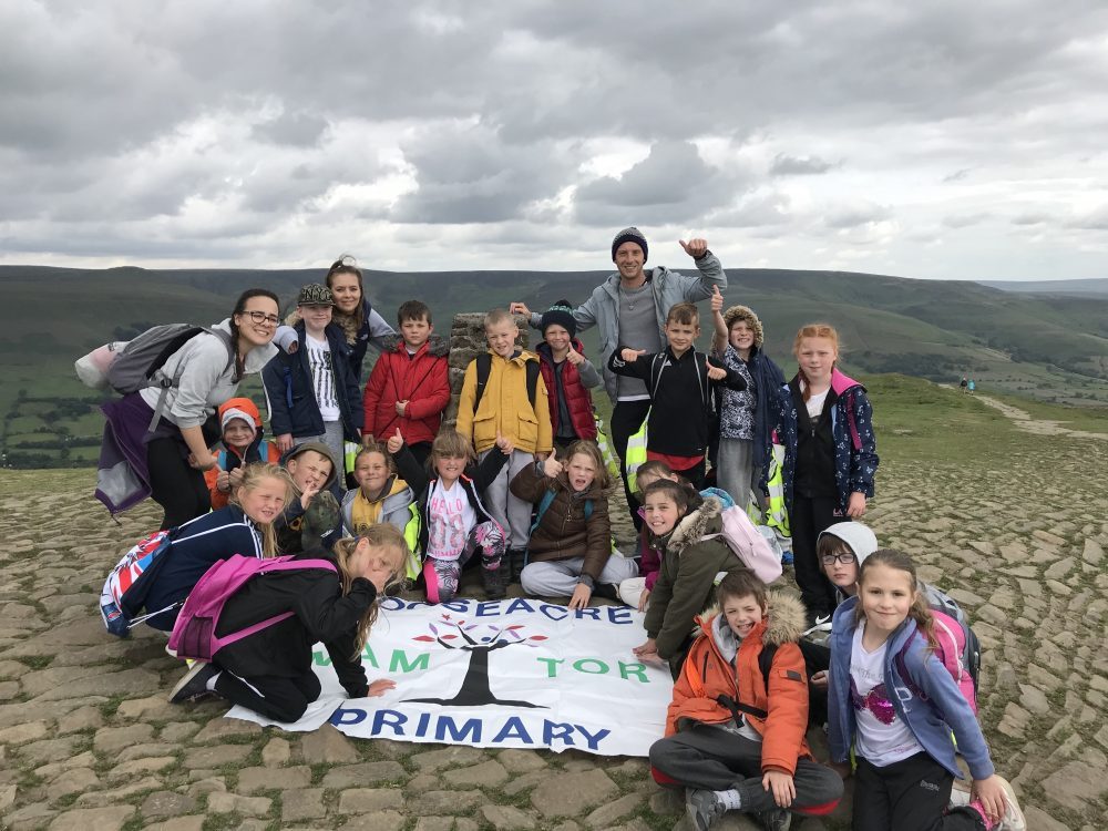 Group of children from Gooseacre Primary celebrating being at the top of Mam Tor.