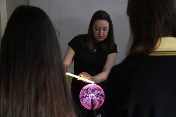 A physics teacher demonstrating to the class the plasma ball lamp