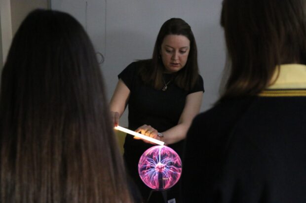 A physics teacher demonstrating to the class the plasma ball lamp