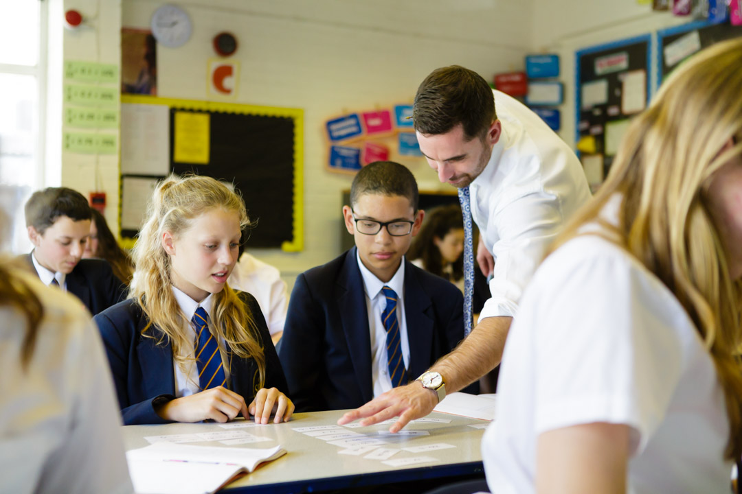 Teacher helping two pupils in the classroom