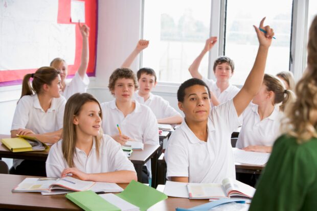 Secondary children with their hands in the air