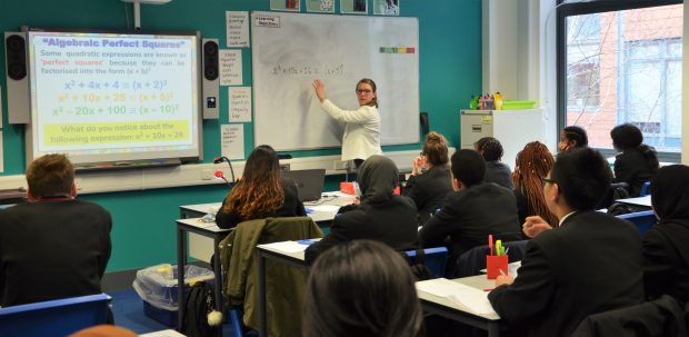 female scondary school teacher at the front of the classroom