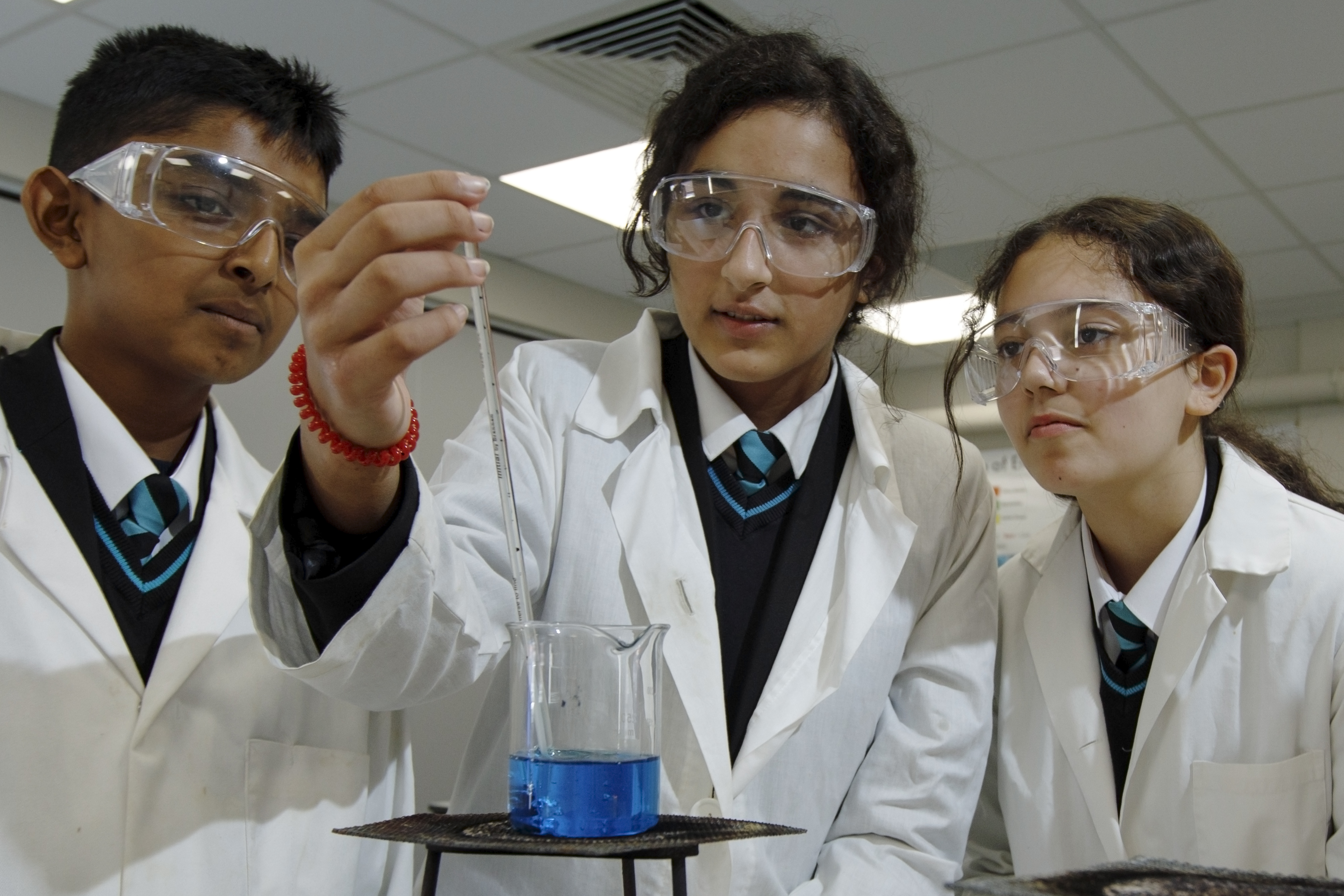 3 Year 9 pupils conduct an experiment in the science lab at Rivers Academy