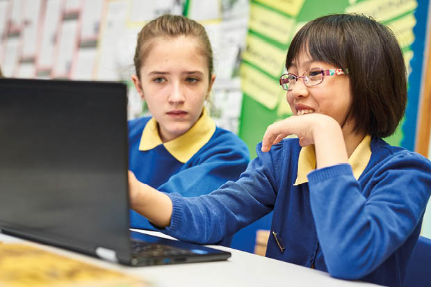 Two young girls working on a laptop from Dawlish Primary School.