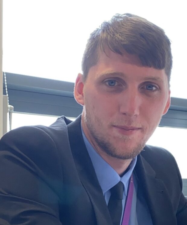 Kieran Anderson, wearing a suit, looking directly at the camera