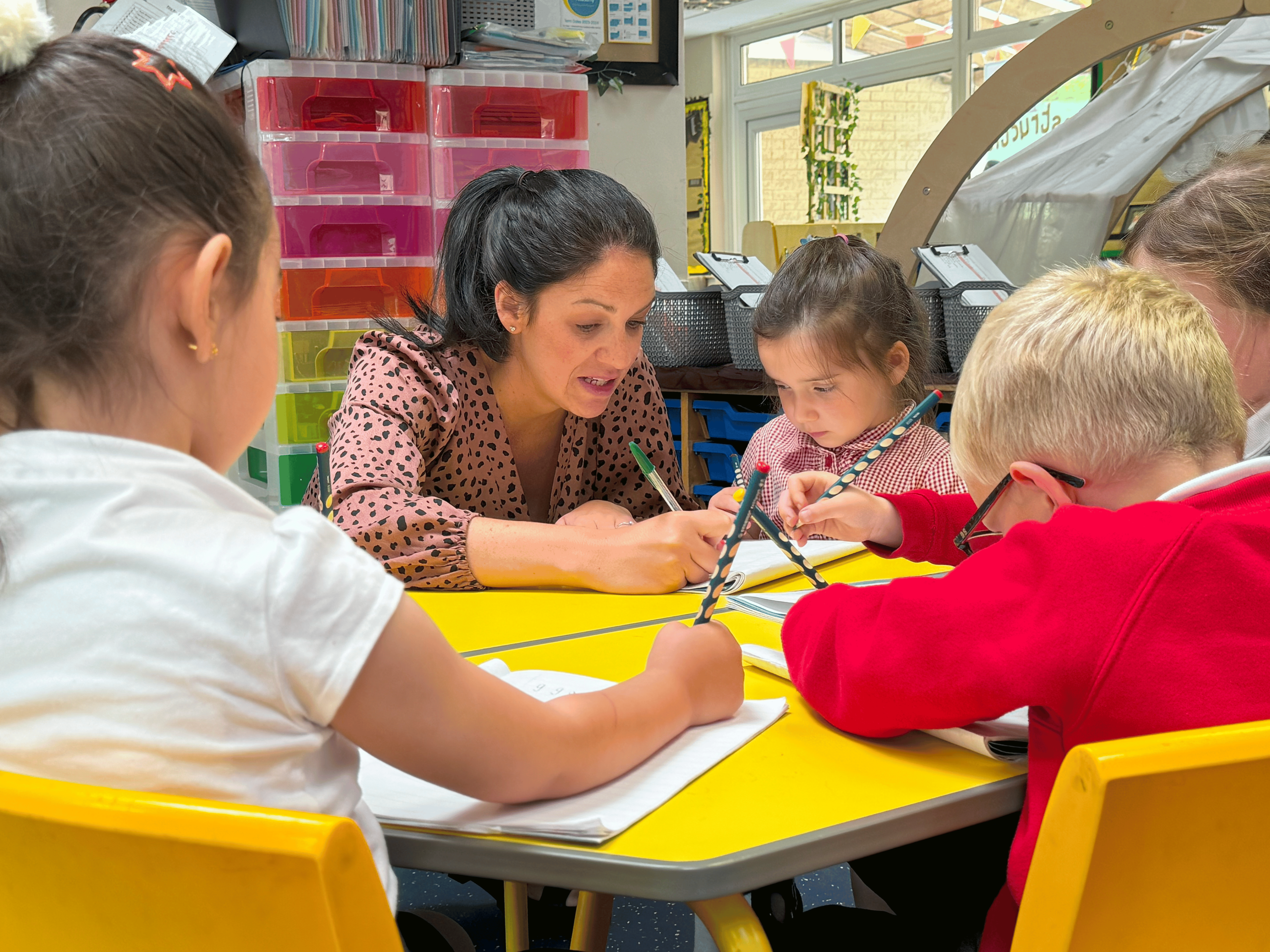 A teacher supporting their students in the classroom